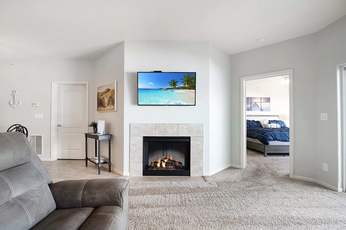 This cozy living area features a fireplace, an armchair, and a television, with a warm, inviting ambiance. The arrangement suggests a perfect spot to unwind during cooler months, enjoy quiet evenings, or socialize in an intimate setting.